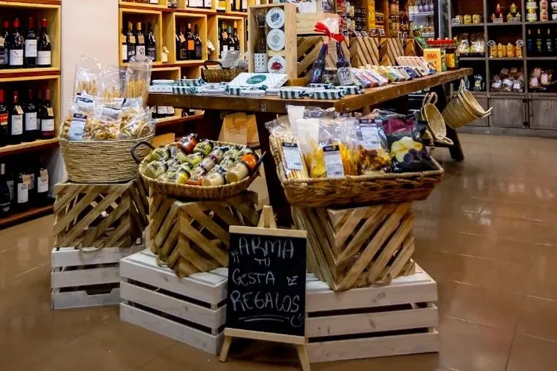 Cestas de regalo y cajas de madera en la tienda El Escondite Gourmet, con una pizarra que dice «Arma tu cesta de regalos»